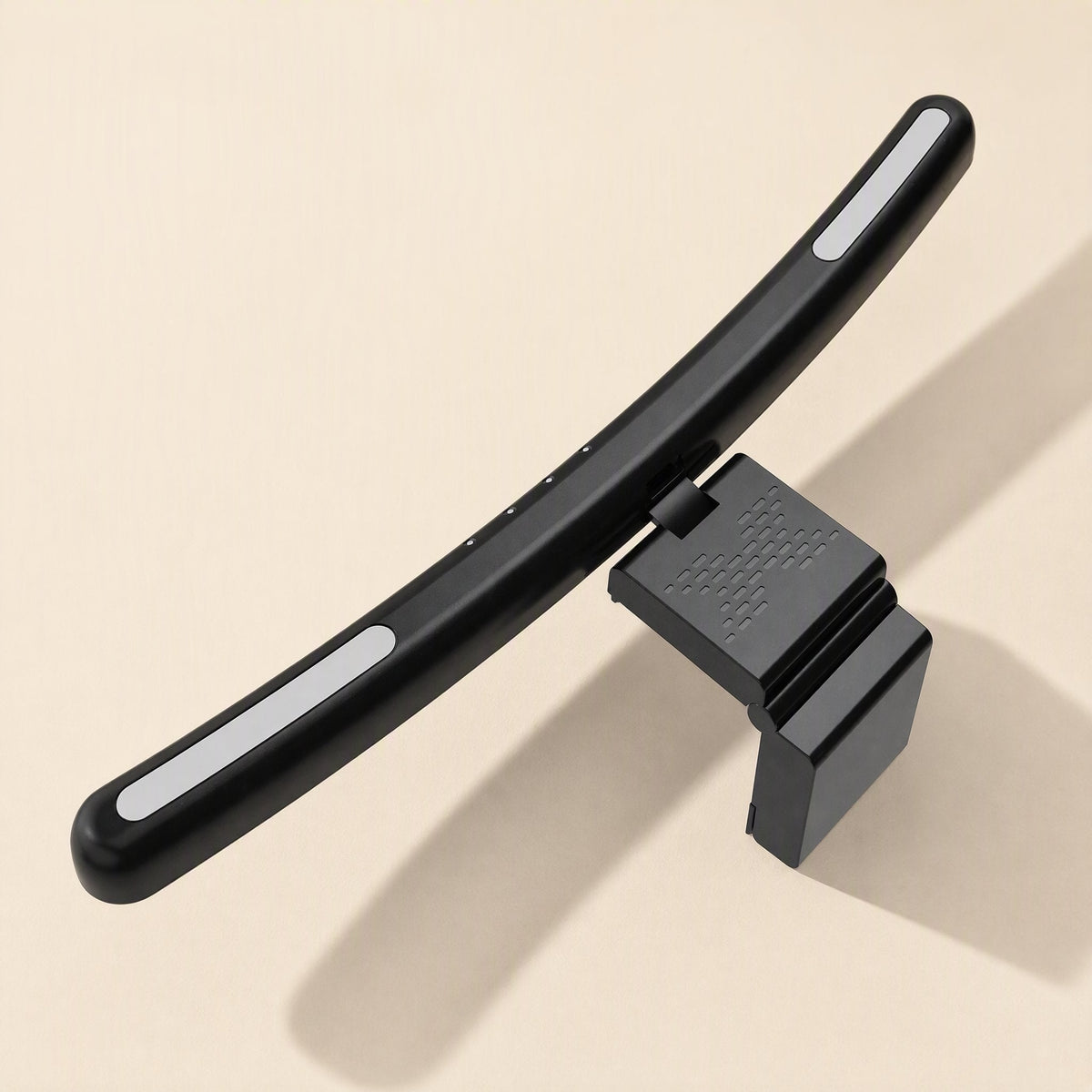Screenhalo – Back view of the black lamp bar with white side glow and textured monitor clip on a beige surface
