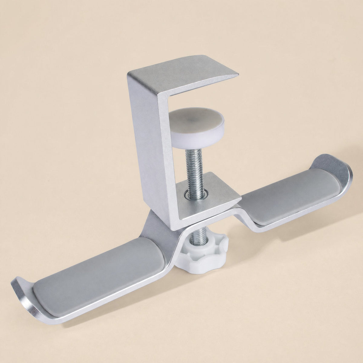Aluturn Headphone Stand – silver aluminum clamp stand with a white screw knob and grey padded hooks on a beige backdrop