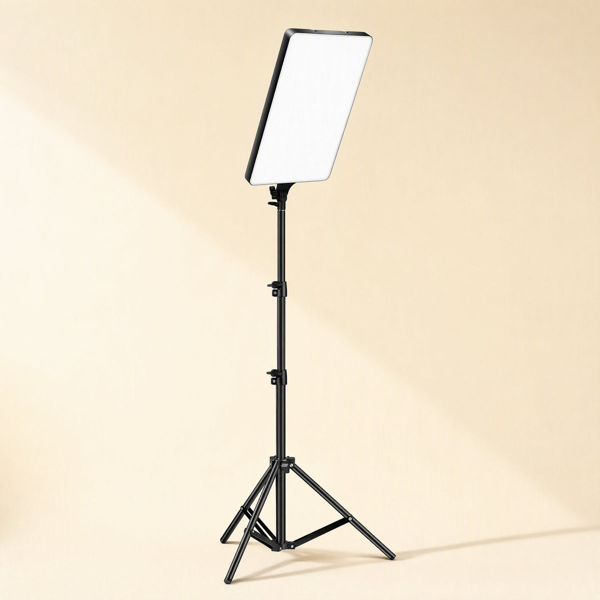 Softbeam – Fill light panel mounted atop a tall black tripod stand with extendable legs on a beige background