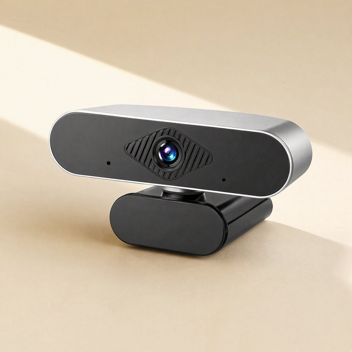 Pixelgleam – Close-up of the silver-edged webcam with diamond-textured lens panel and two small microphone holes