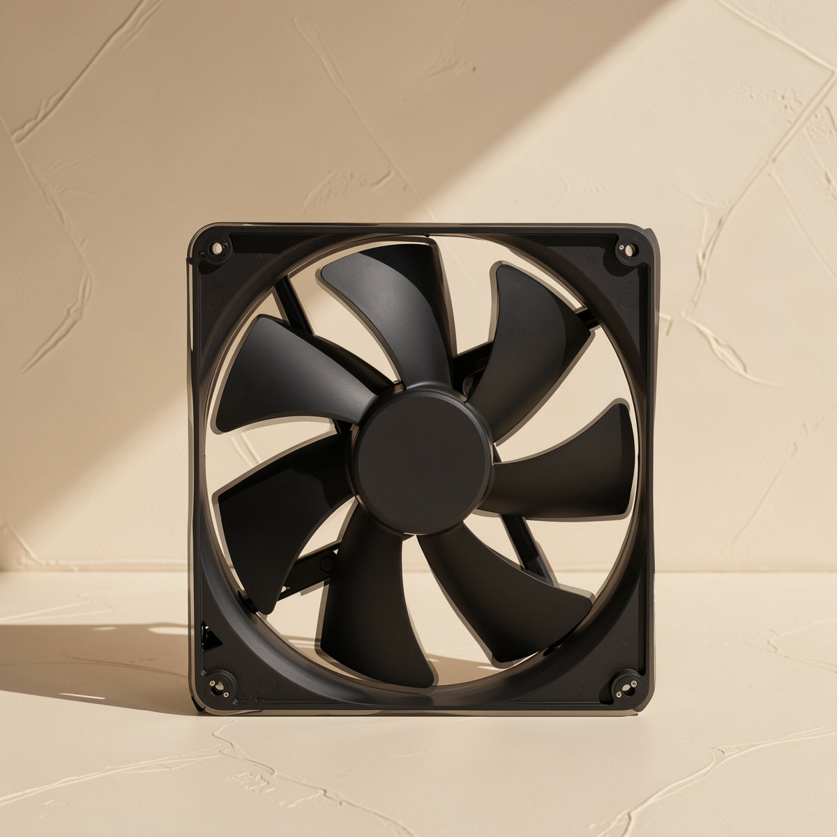 Bladechill – Straight-on view of the black fan's curved blades and central hub against a textured cream wall