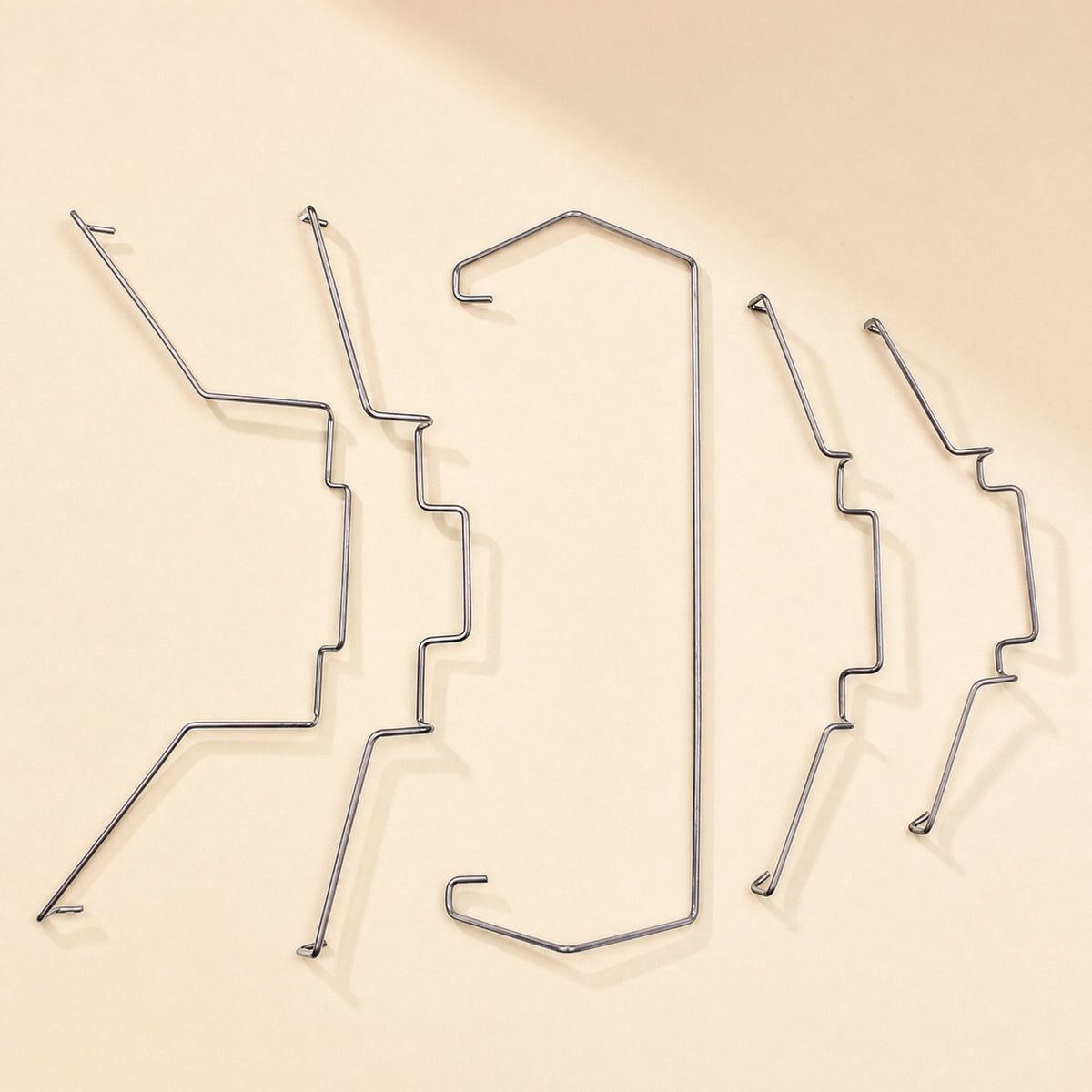 Fanclasp – Five bent steel wire fan clips in varied shapes arranged side by side, including one long U-shaped clip
