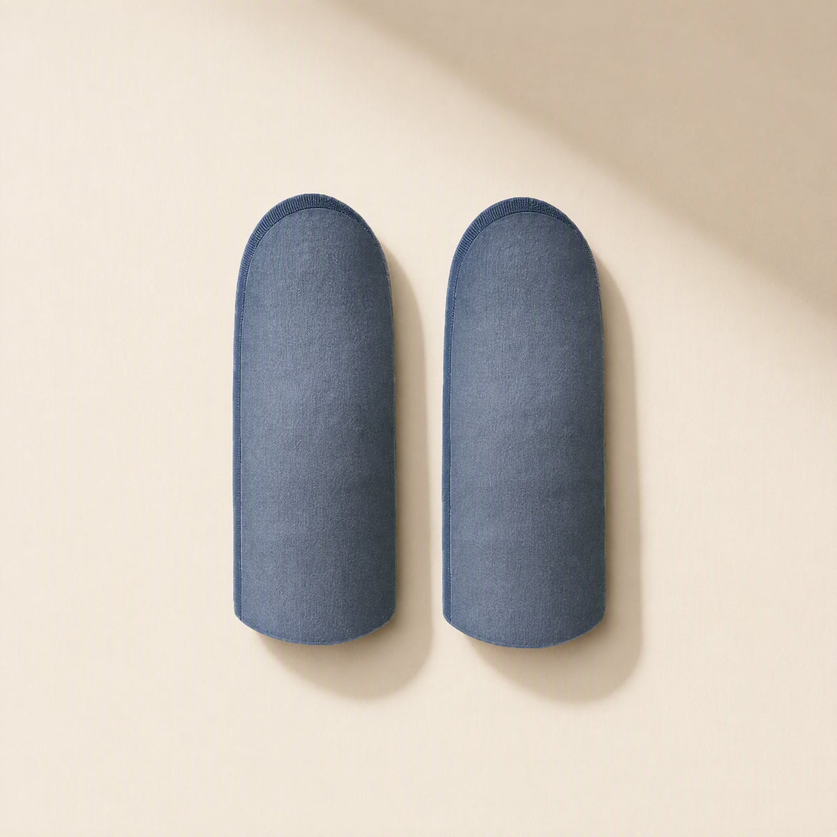 Silvertouch – Two blue-gray finger sleeves lying flat side by side on a cream background, seen from above