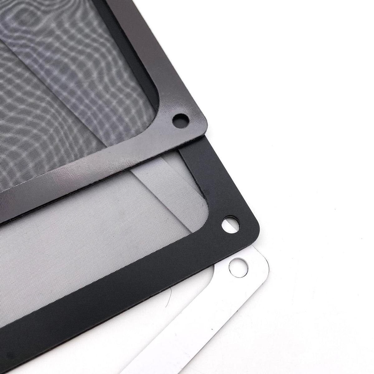 Ventmesh – Corner detail of stacked black and white filter frames with round screw holes and gray mesh