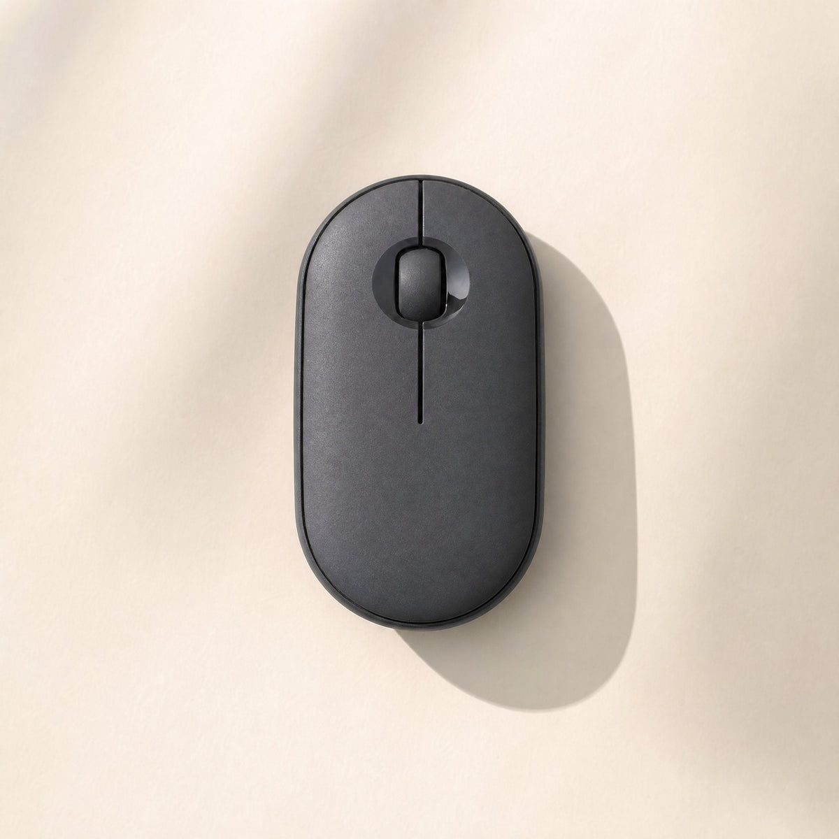Quietcursor – Black wireless mouse seen from above, with a matte finish and scroll wheel, casting a soft shadow