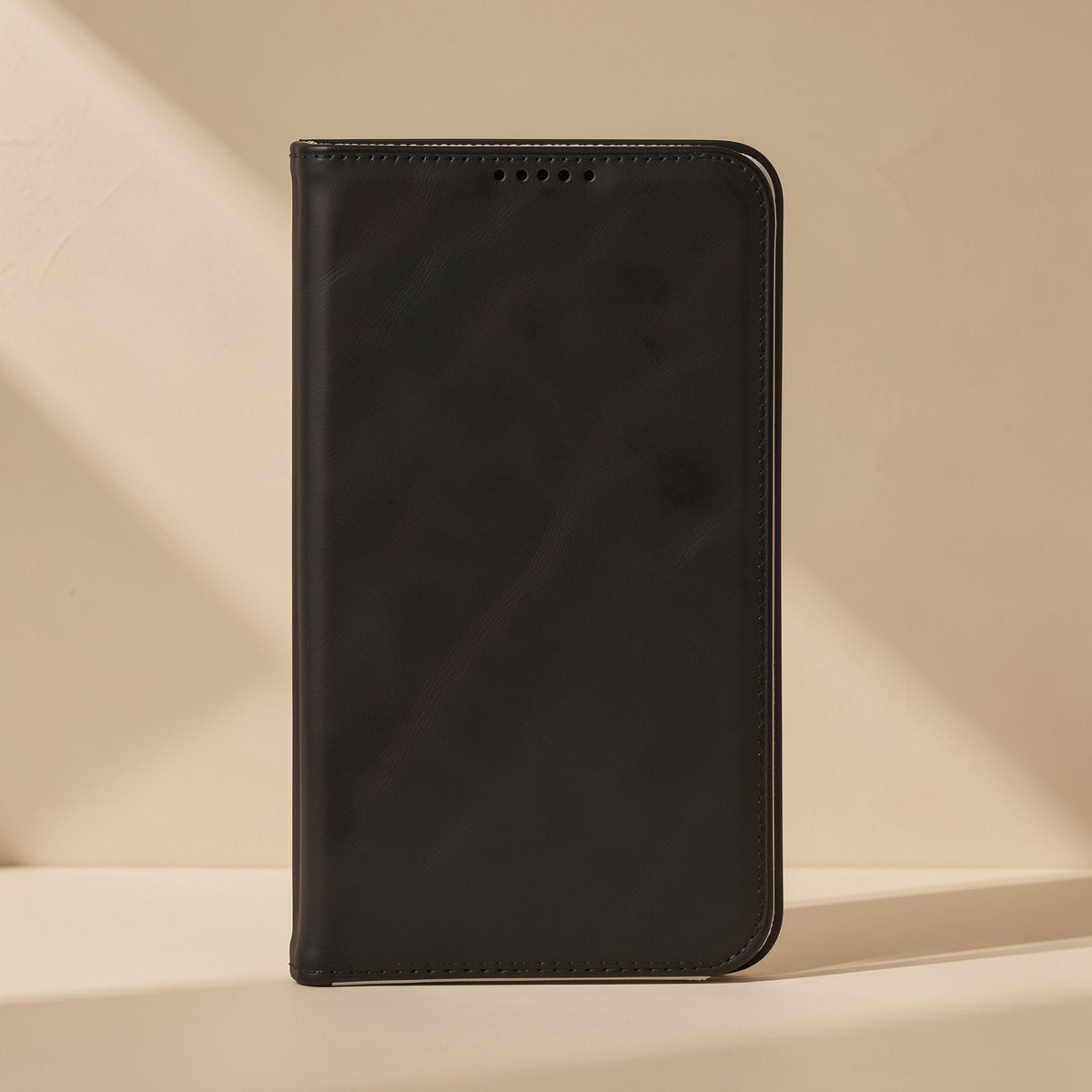 Softshell – Black flip cover standing upright, front flap with five small speaker holes and stitched edges