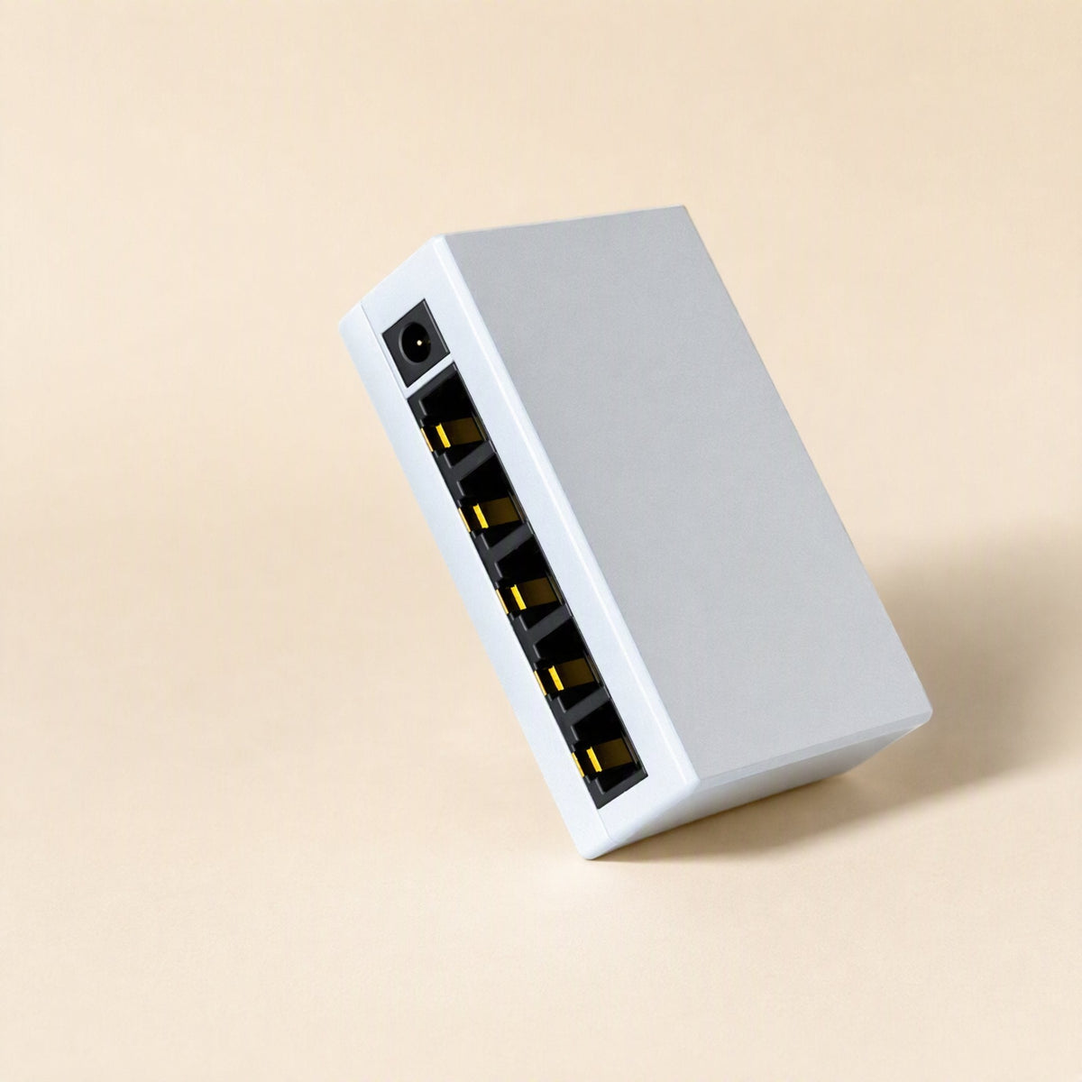 Deskport – White network switch standing on its side, showing the power jack and a column of Ethernet ports