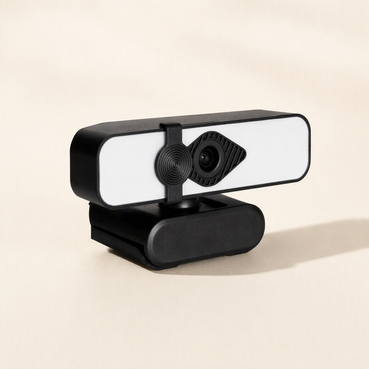 Camclarity – Black clip-base webcam with white light panel, three-quarter view casting a soft shadow on beige