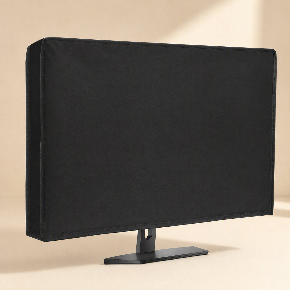 Coverloom Monitor Dust Cover – fitted black cover over a monitor on a stand, seen from the right with a cream backdrop