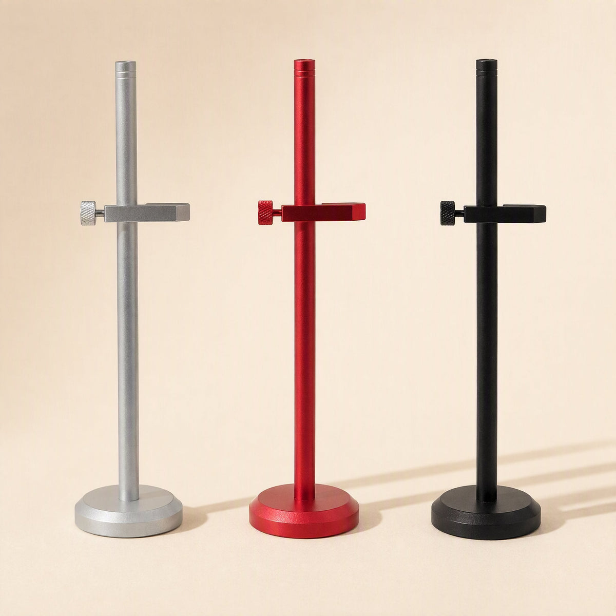 Stronghold – Silver, red and black brackets standing in a row, each with one clamp arm and a round base
