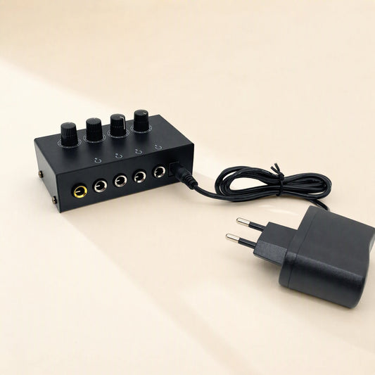 Fourtone – Headphone amplifier front panel with five jacks and a power cord plugged in beside a black EU wall adapter