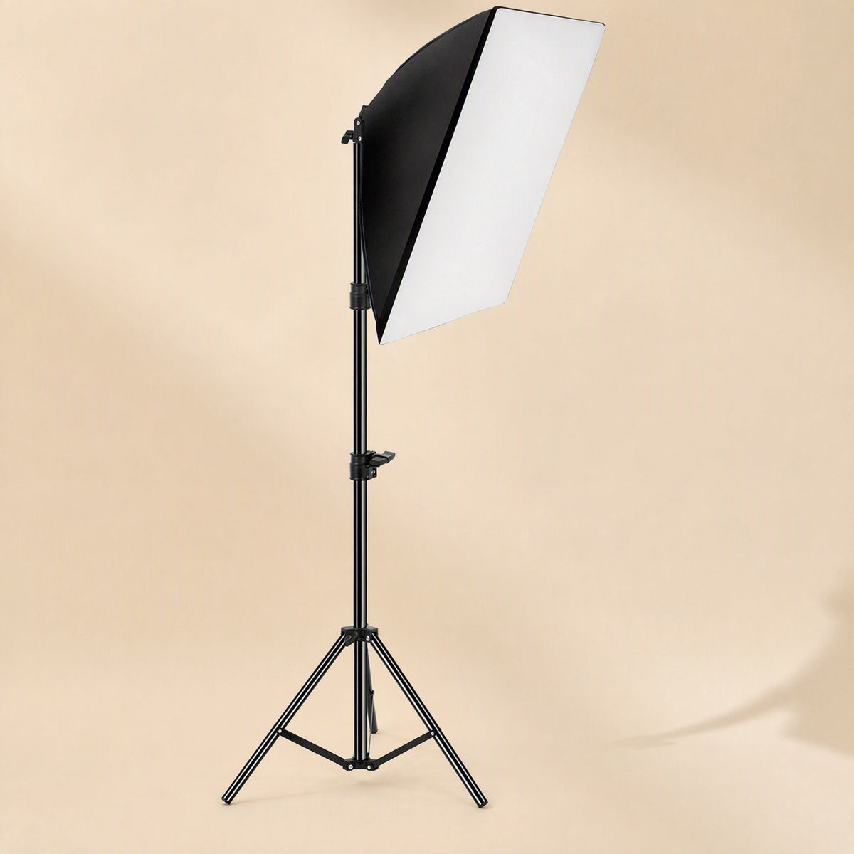 Faceglow – Softbox light on an extended tripod stand viewed from the front, with a beige studio wall behind