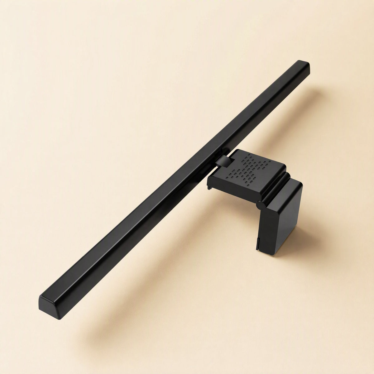Dimperch – Rear view of the black light bar and its clip with a vented top, resting on a beige surface