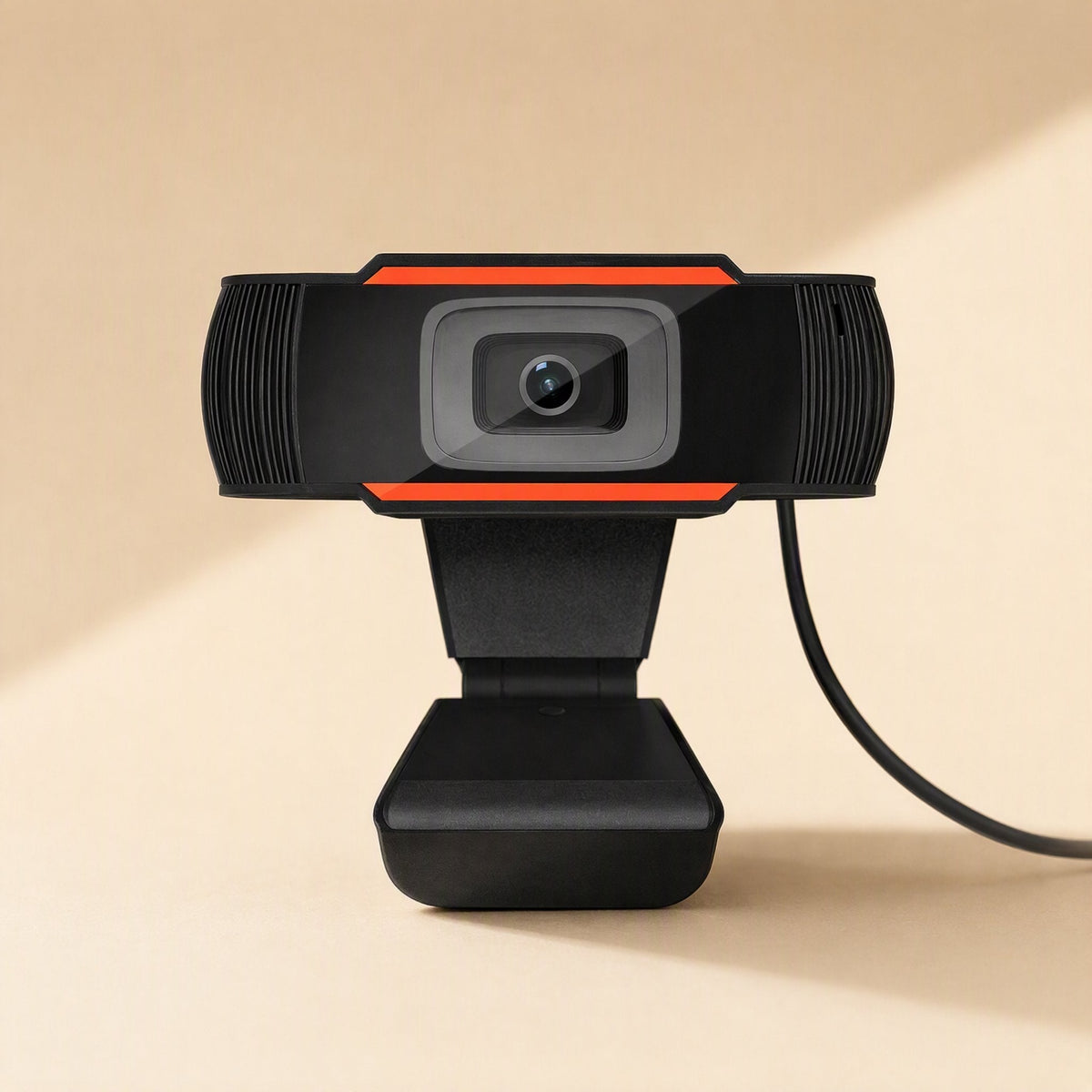 Voicelens – Straight-on close view of the webcam lens, orange bars and ribbed speaker panels in a sunlit beige setting