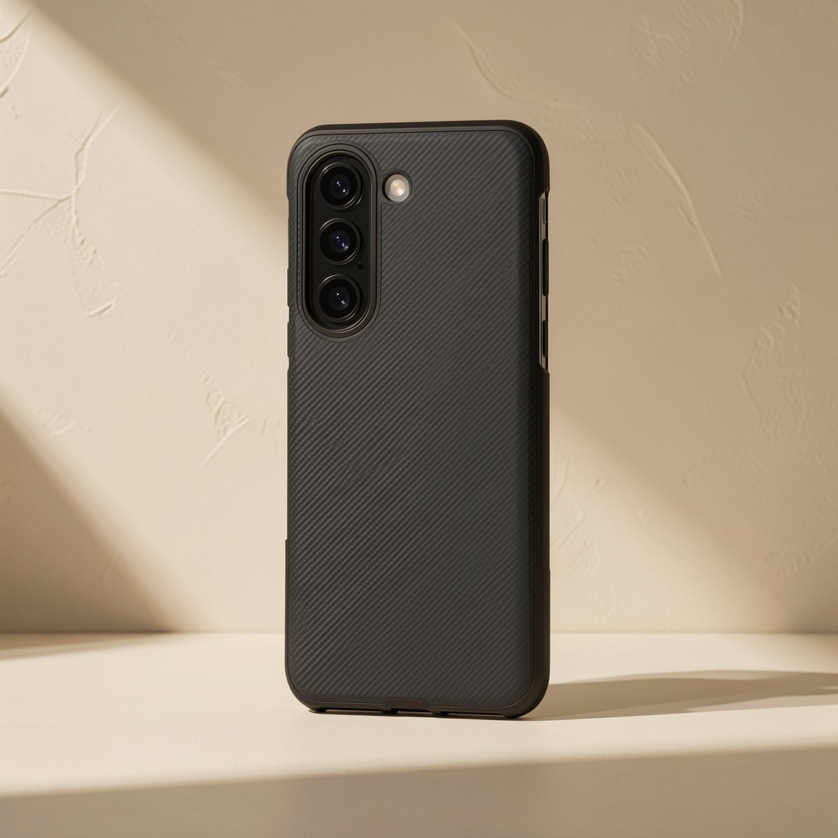Flipgrain – Black textured case at a three-quarter angle showing side button cutouts and triple camera ring