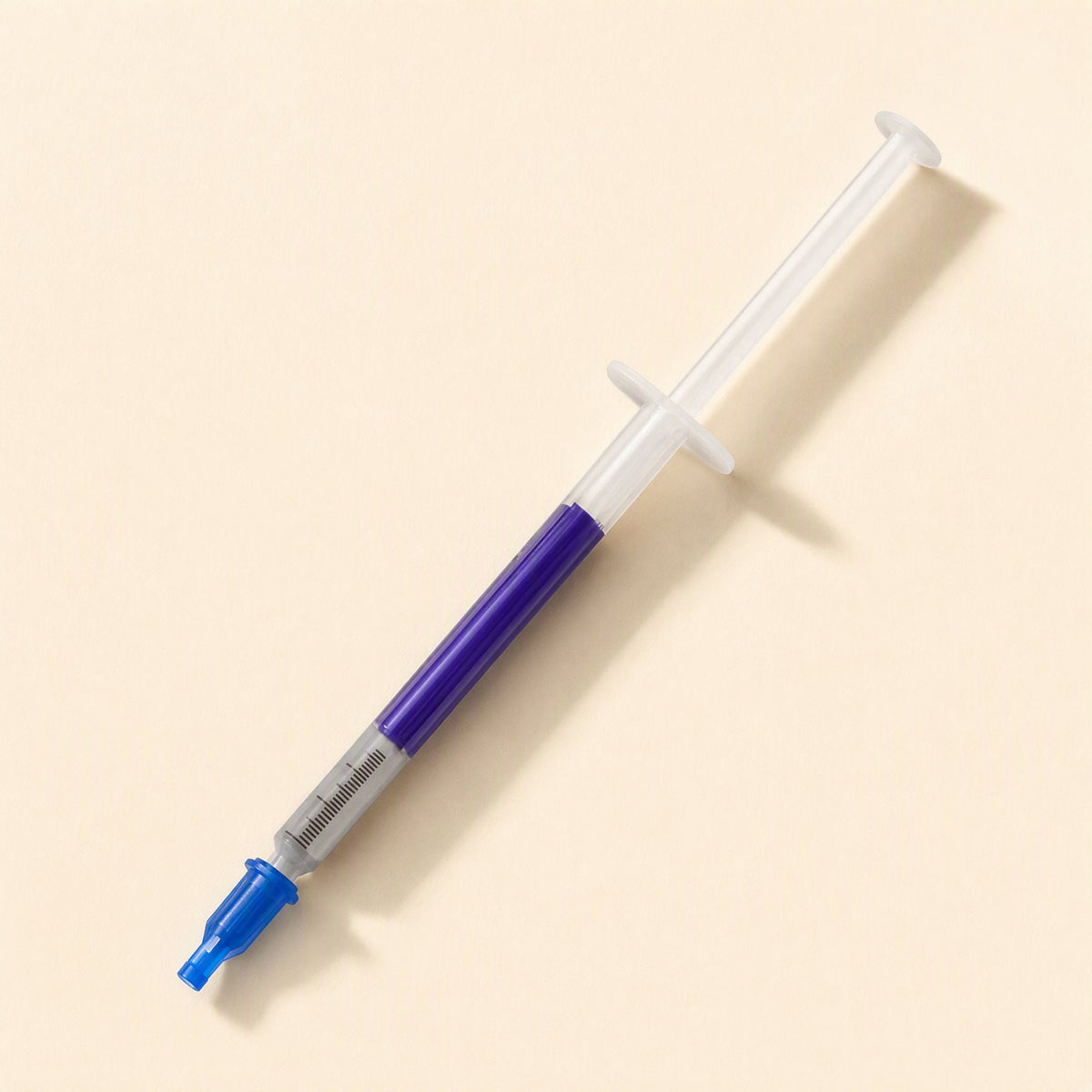 Thermspread – Syringe with the blue cap removed and placed on the tip, showing the purple paste inside the barrel