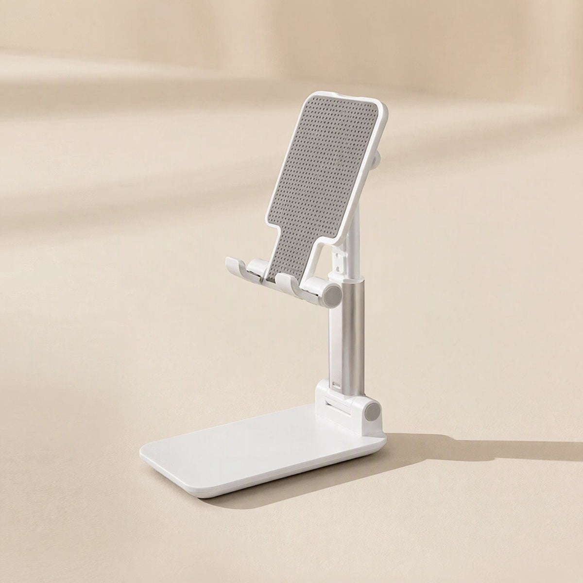 Phonehinge – White folding phone stand extended at an angle on a beige background with a soft shadow