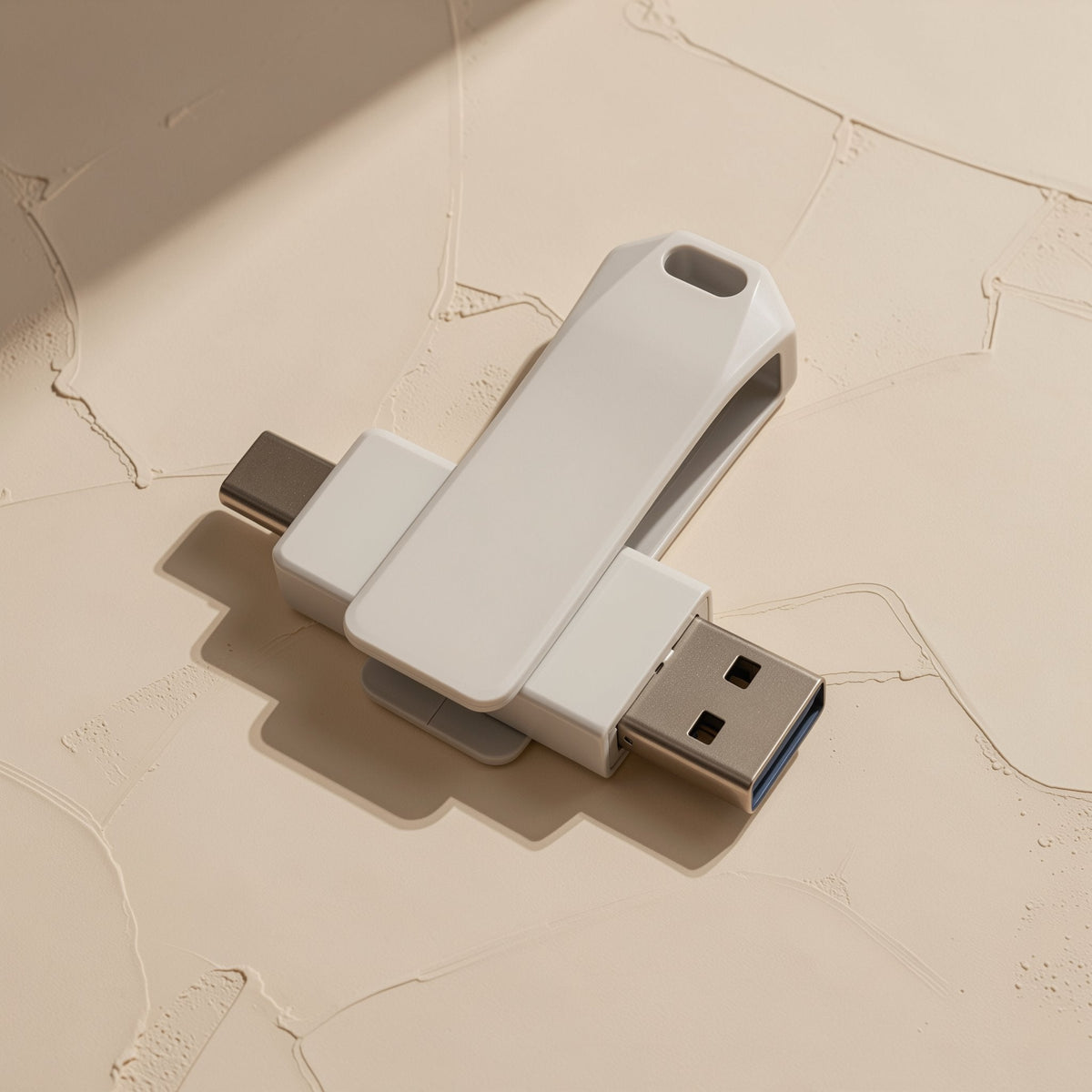 Typeflash – White swivel drive with USB-C and USB-A connectors both extended, seen from above on cracked plaster