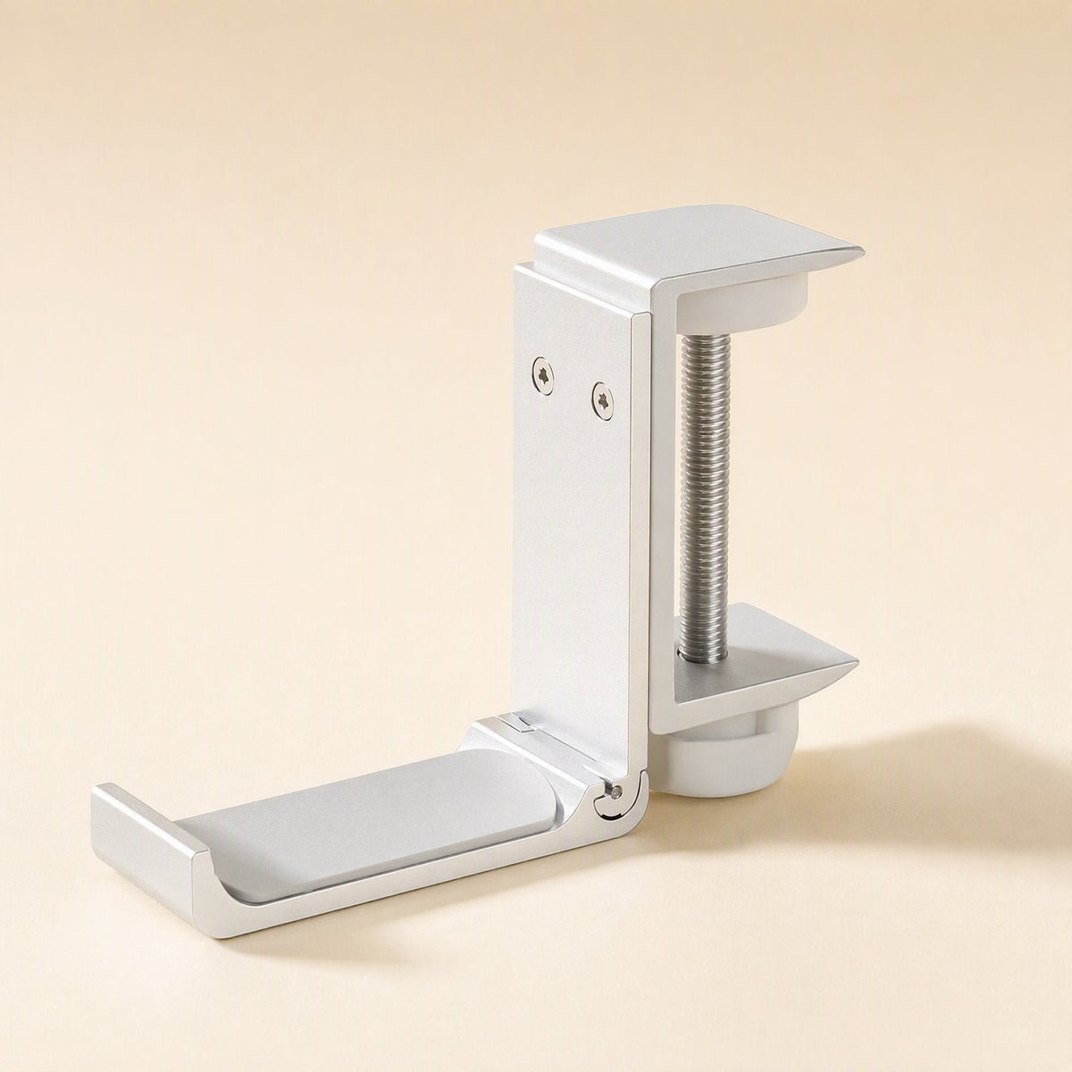 Alloyperch – Silver clamp headphone stand with threaded screw and angled cradle arm on a peach background