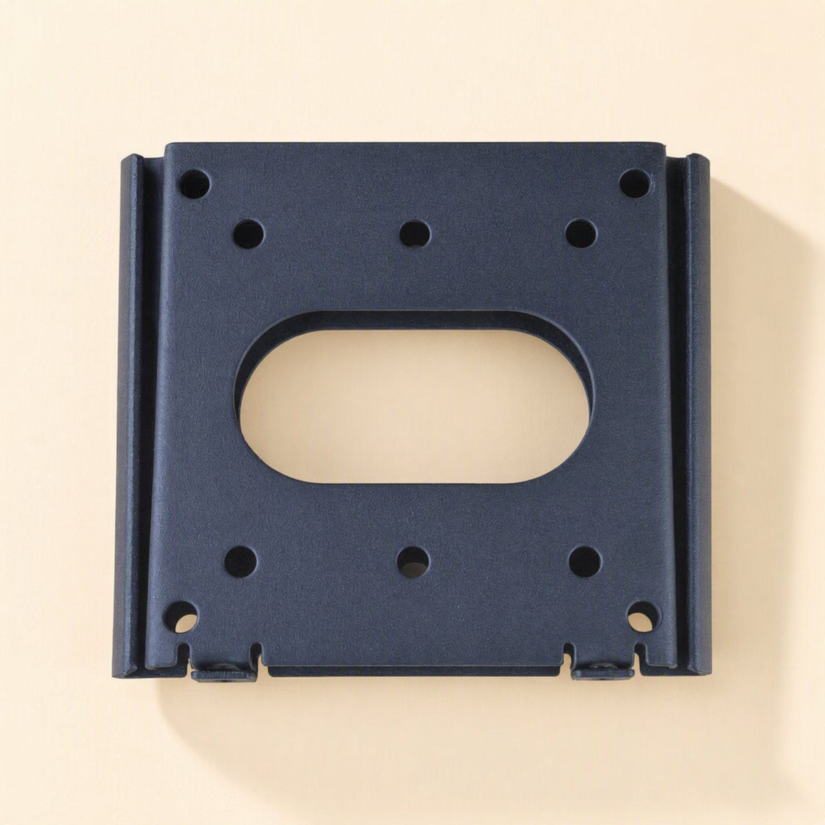 Walllock – Black square bracket plate seen straight on, with oval opening, drilled holes and small tabs along the bottom