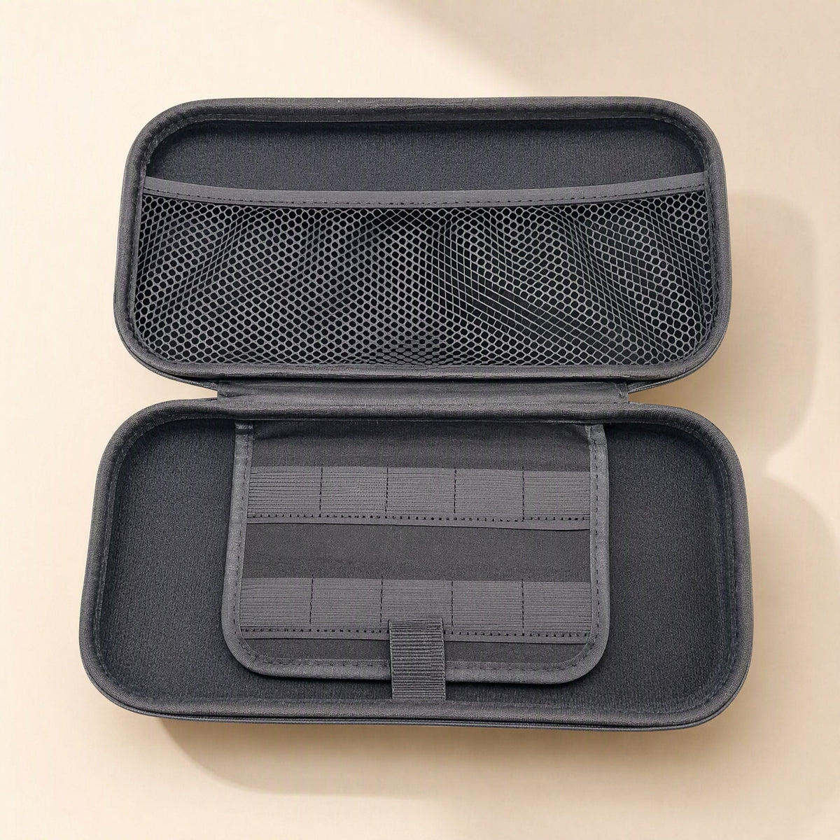 Switchstow – Inside of the gray case showing the mesh pocket on the lid and a game card holder flap with a tab closure