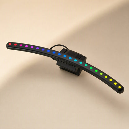 Taskbeam – Curved black light bar with a row of rainbow-coloured LEDs, small touch buttons and clip visible on the back