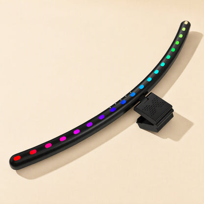 Taskbeam – Overhead view of the curved light bar showing multicolour LED dots and the textured clip on a cream surface