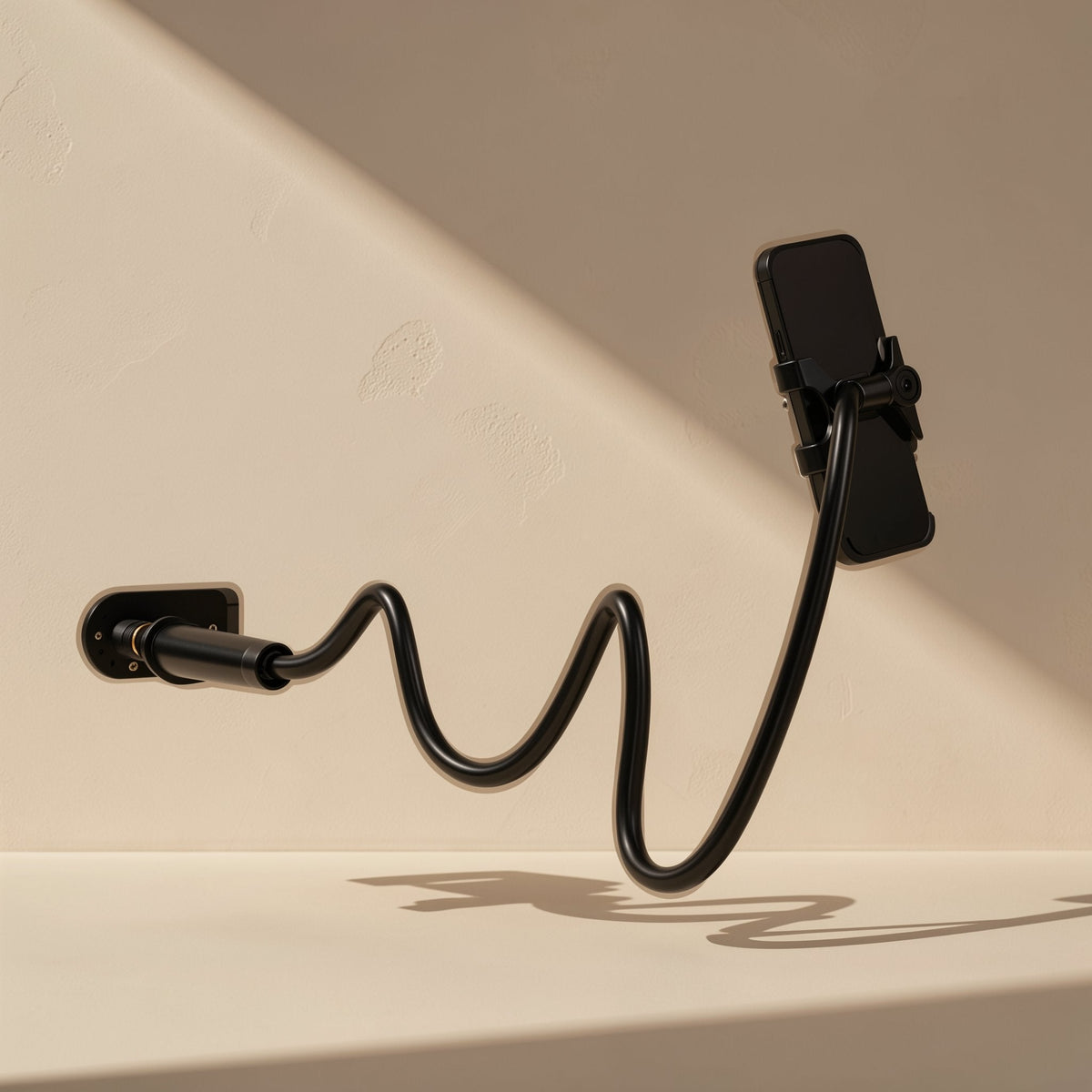 Rotaperch – Black flexible gooseneck arm with a phone holder, bent in an S-curve from a wall mount against a beige wall