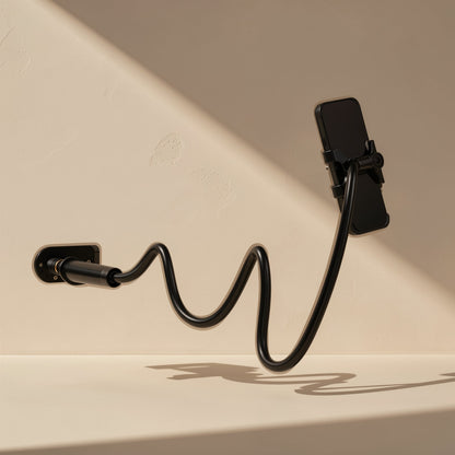 Rotaperch – Black flexible gooseneck arm with a phone holder, bent in an S-curve from a wall mount against a beige wall