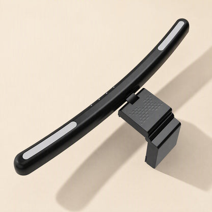 Screenhalo – Back view of the black lamp bar with white side glow and textured monitor clip on a beige surface