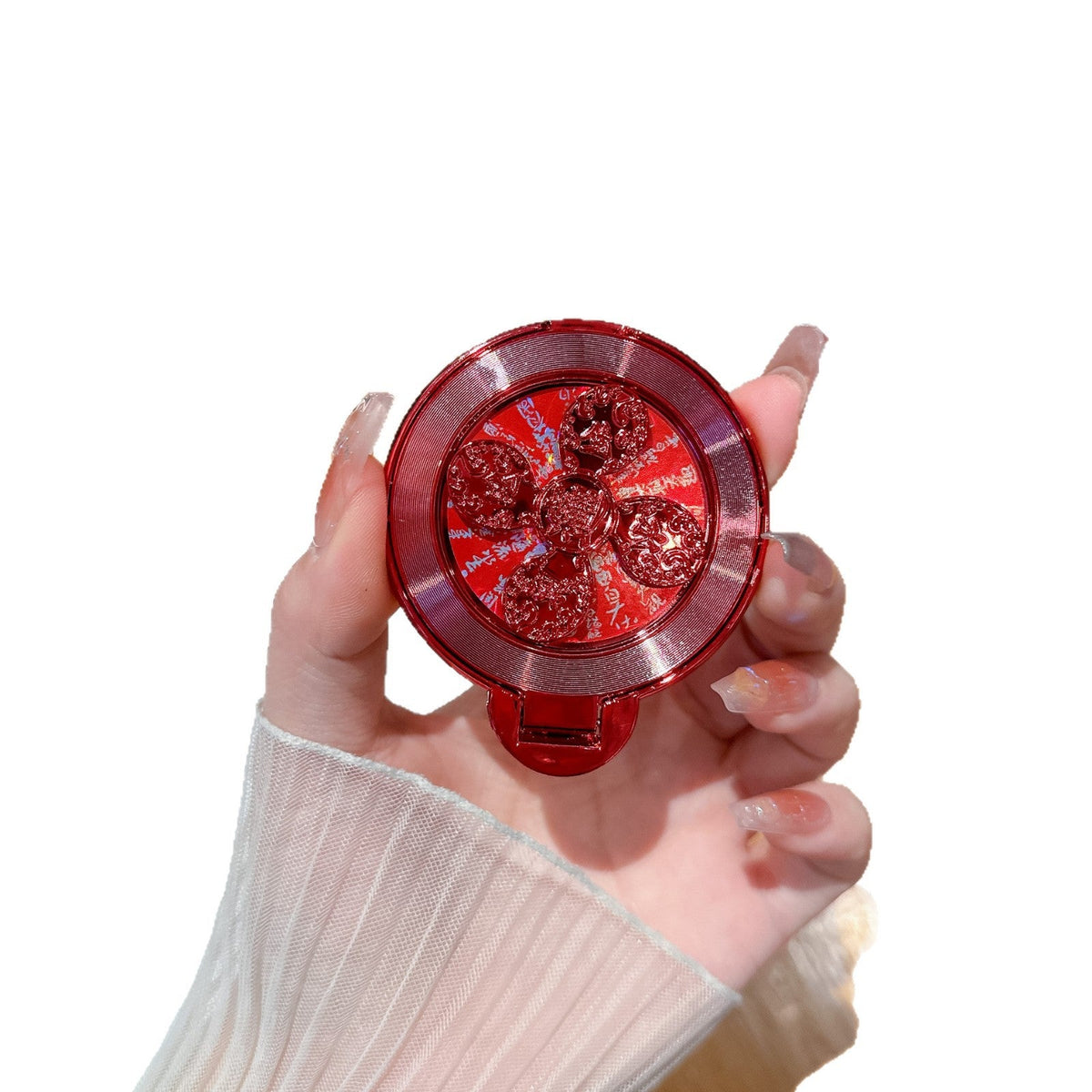 Discperch – Red stand with glittery flower centre held in a hand with pink nails, on a plain white background