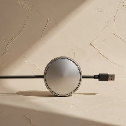 Quickreel – Side view of the round brushed-metal cable reel with a black USB-A plug extending from one side