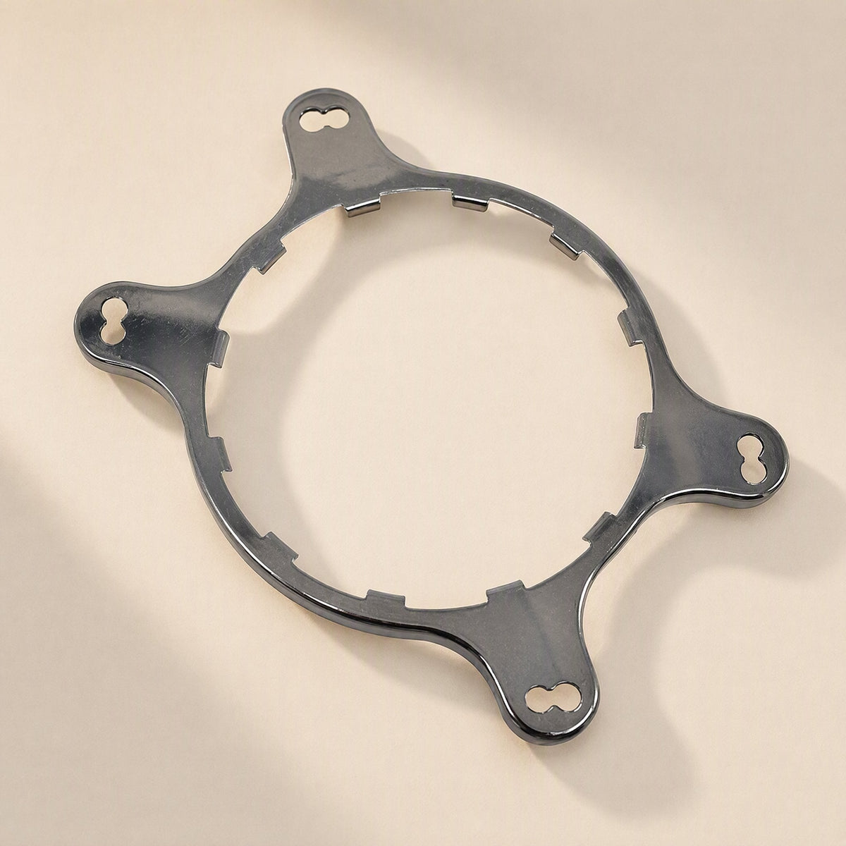 Coolmount – Angled view of the bare steel mounting ring with four keyhole slots and notched inner edge