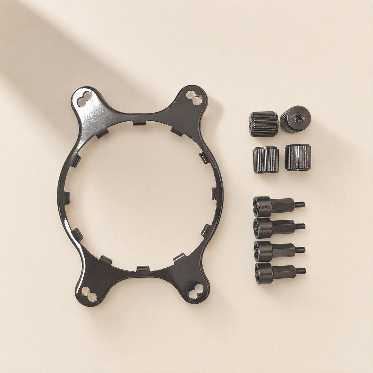 Coolmount – Overhead view of the black bracket with four standoffs and four thumbscrews, two screws shown from the side