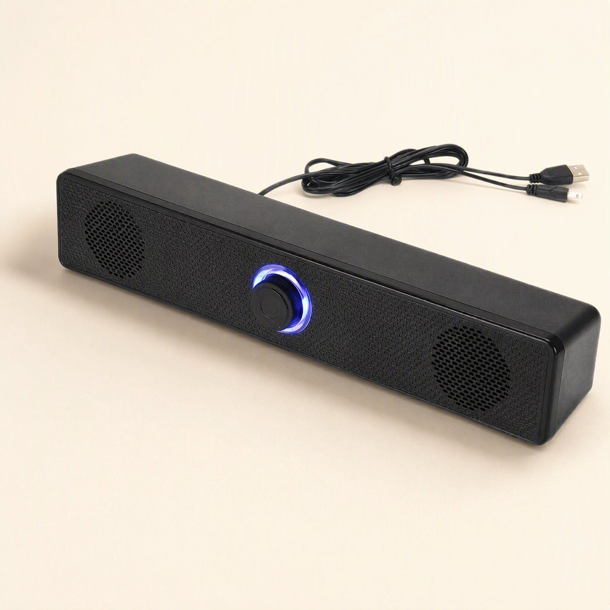 Wiretune – Close angled shot of the black speaker's blue-lit knob and mesh grille, with USB cable curled behind