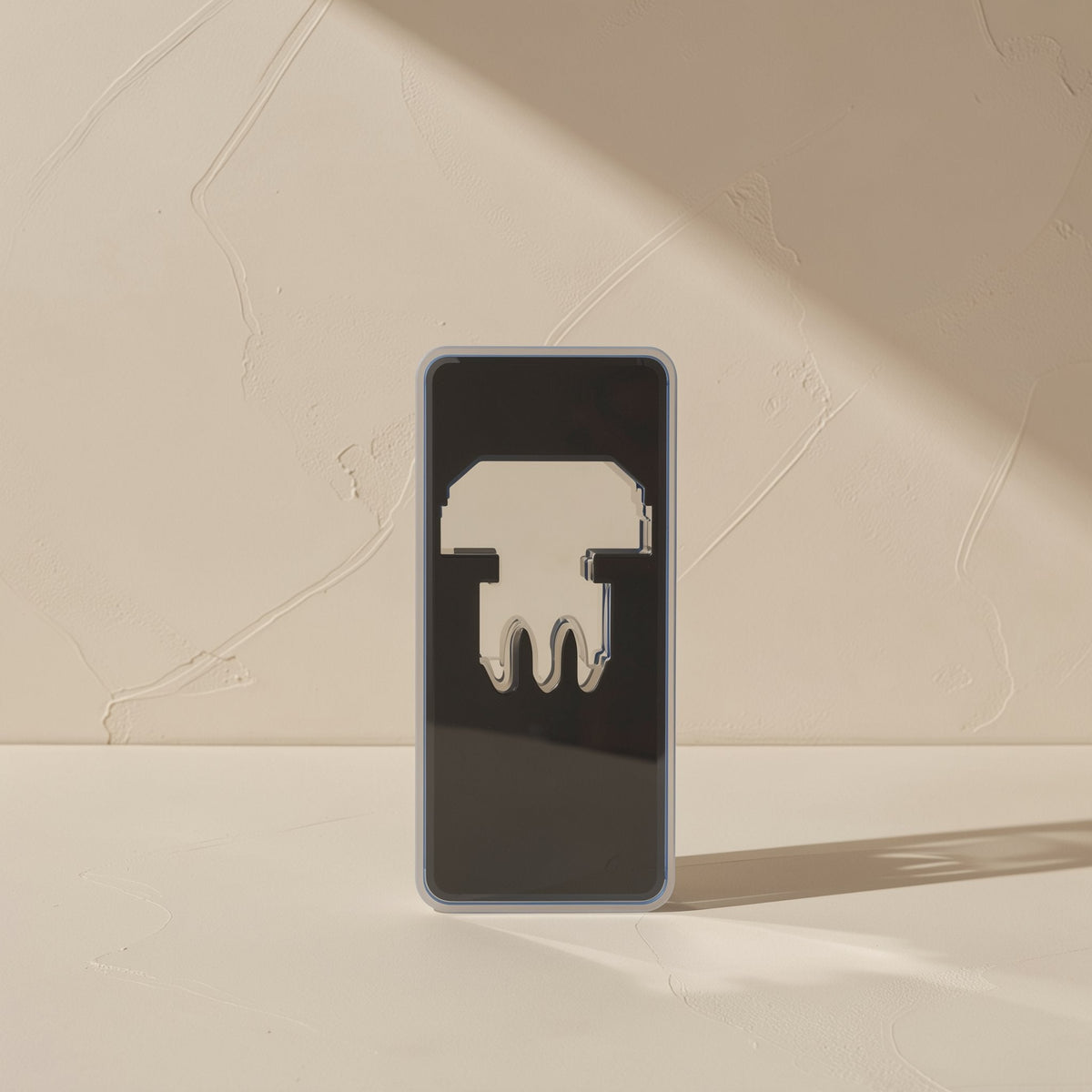 Jackmate – Dark rectangular box with a connector silhouette printed on the front, standing against a plaster wall