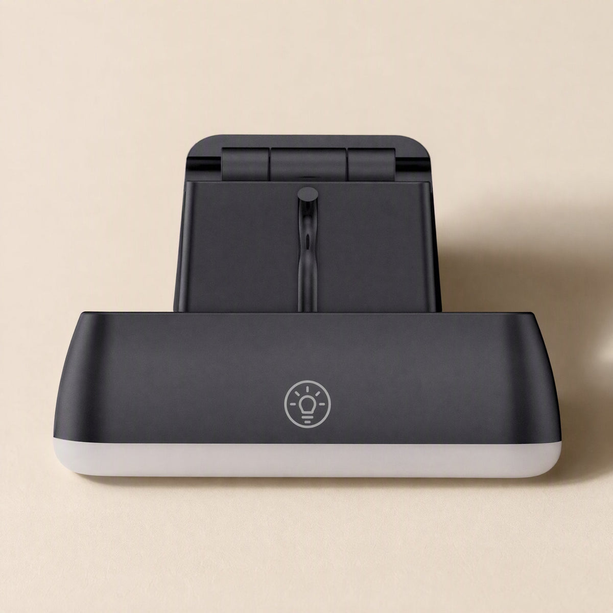 Screenface – Top view of the black webcam with a lightbulb icon on the light panel and folded stand behind