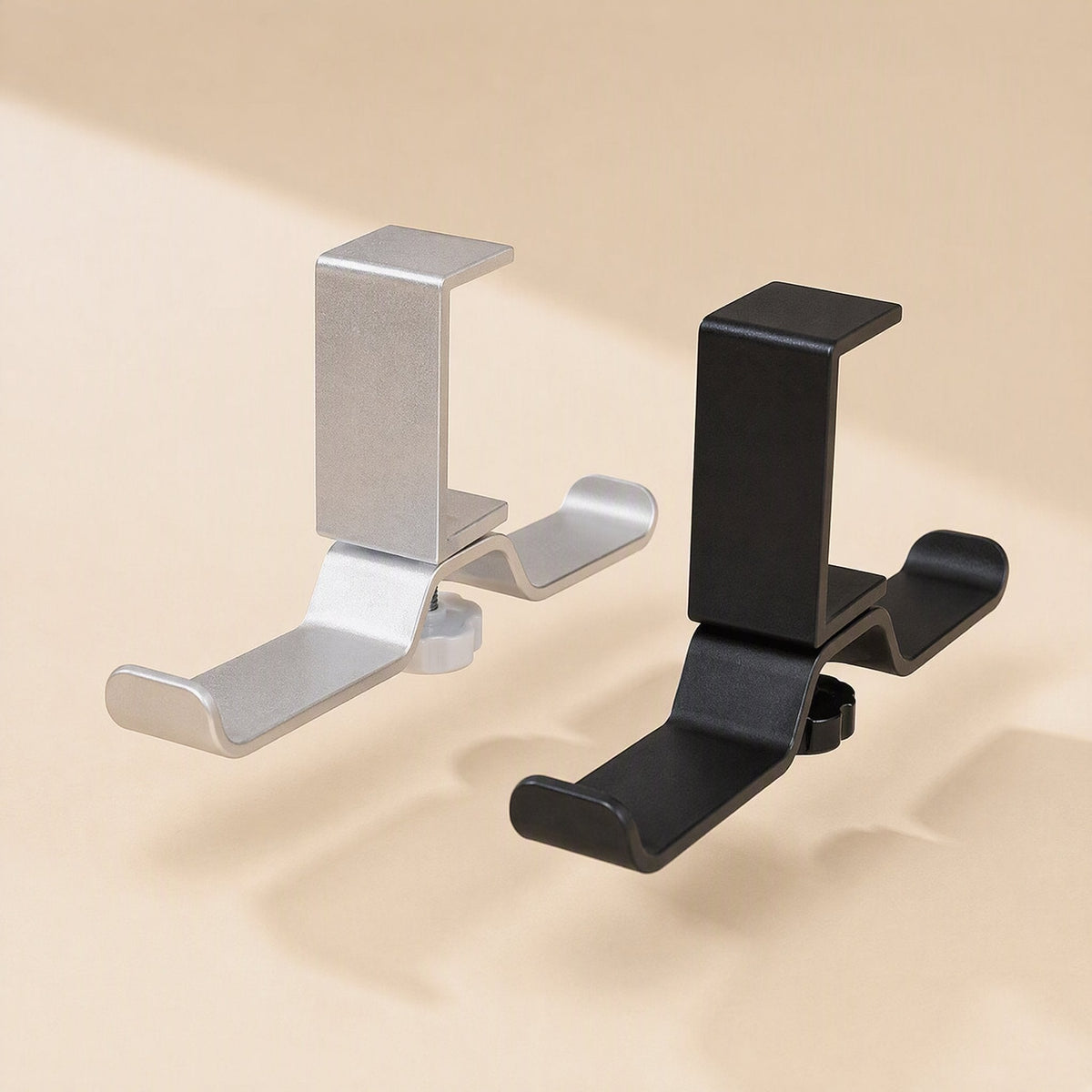 Aluturn Headphone Stand in silver and black, shown side by side on a beige background