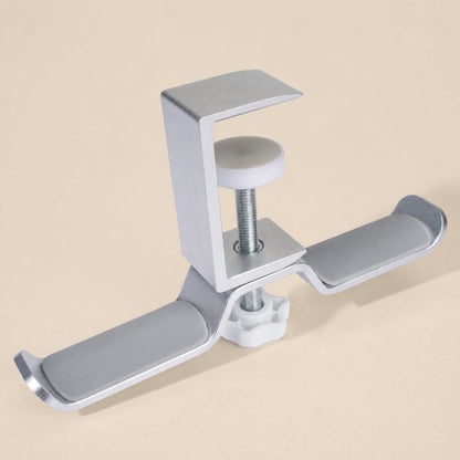 Aluturn Headphone Stand – silver aluminum clamp stand with a white screw knob and grey padded hooks on a beige backdrop