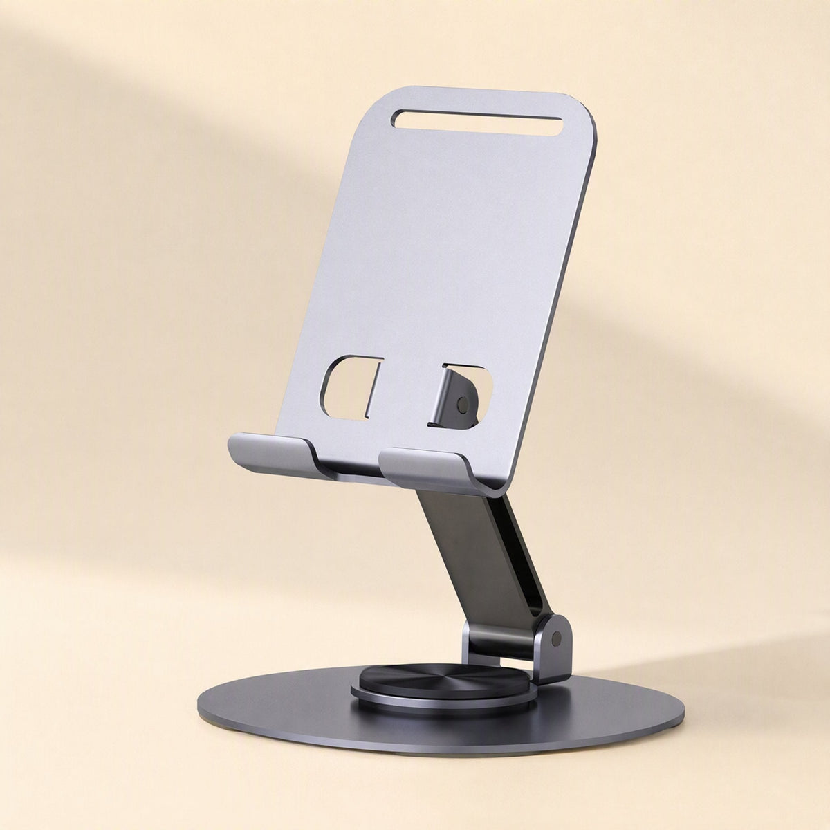 Steadyprop – Silver-gray folding phone stand with cutout holes in the back plate and a round base, front view