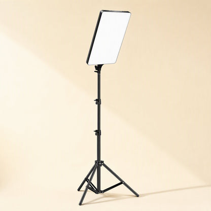 Softbeam – Fill light panel mounted atop a tall black tripod stand with extendable legs on a beige background