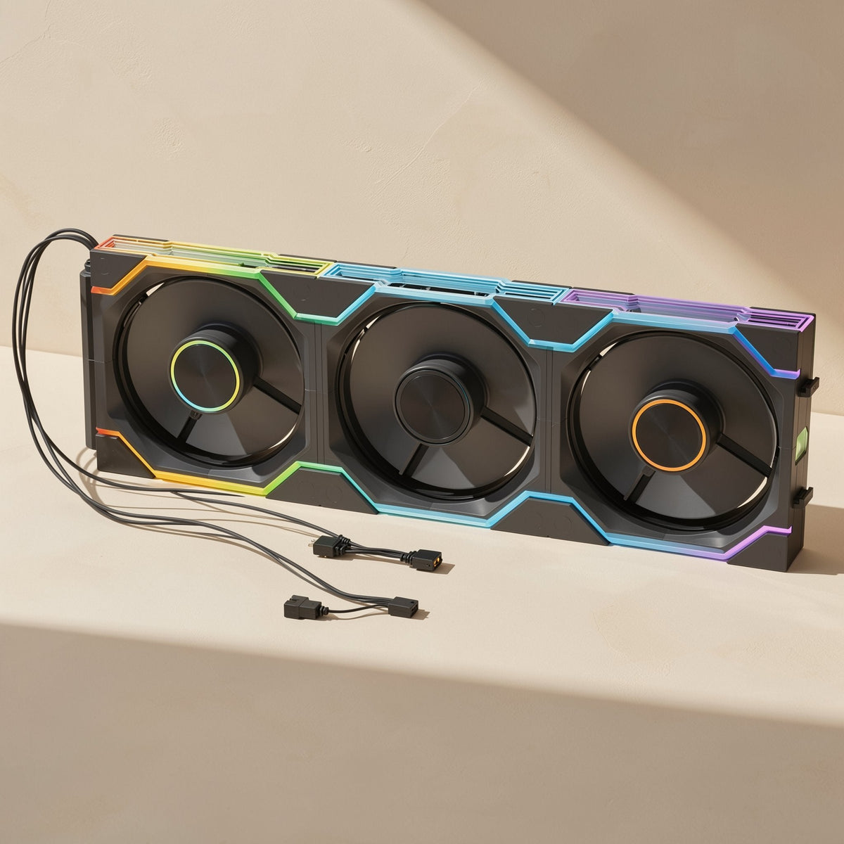Coolspin – Black triple-fan unit with rainbow RGB lighting, ring-lit hubs, and three trailing cables in front