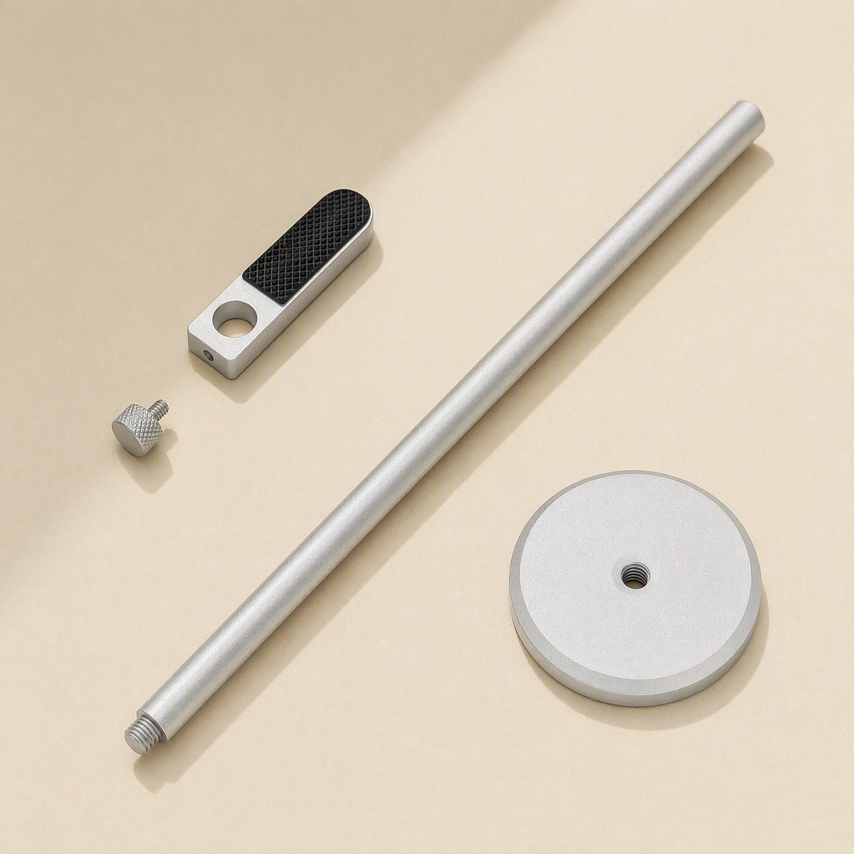 Alloybrace – Silver bracket parts laid flat: pole, textured support arm, thumbscrew and round magnetic base