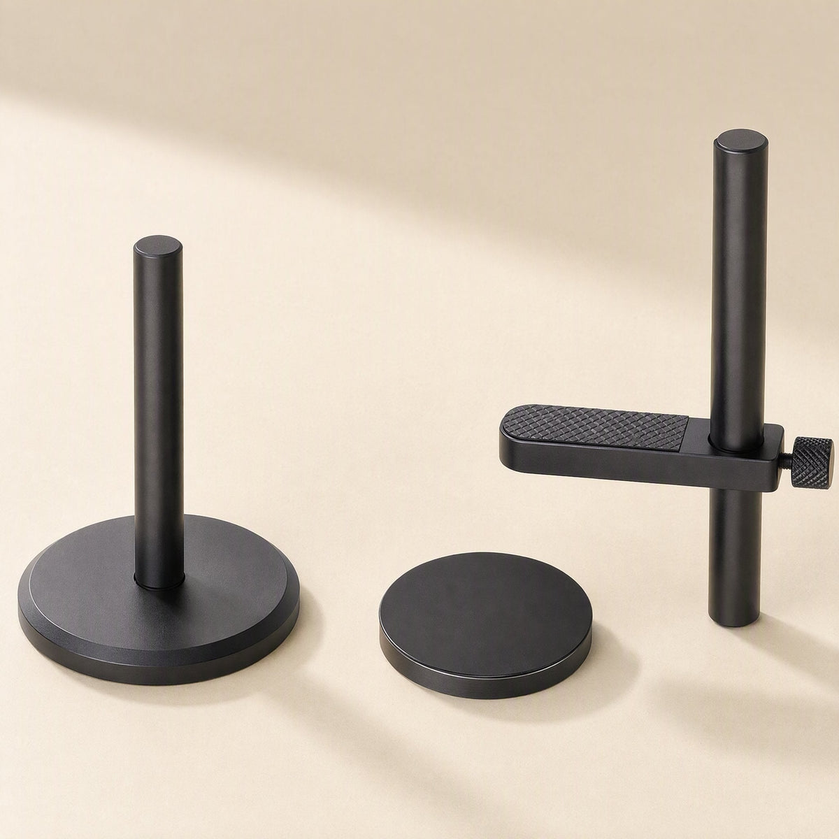 Alloybrace – Black bracket separated into pieces: pole on base, loose magnetic disc, and arm with textured pad