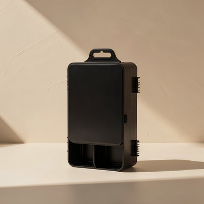 Screwkit – Closed black case standing upright with a carry handle on top, against a textured beige wall