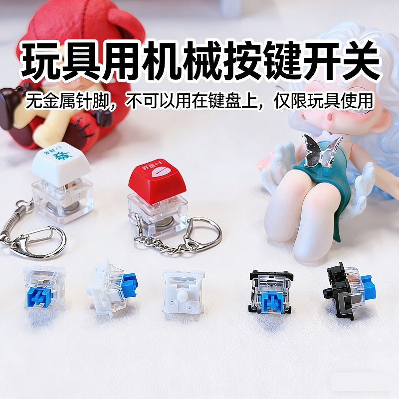 Crispop blue switch keychain toy with red and white keycap keychains and loose switches beside art toys
