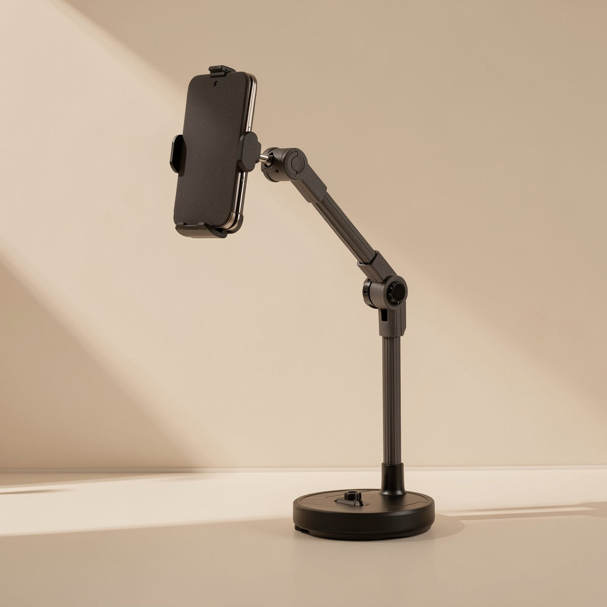 Streamstead – Black stand with a phone held upright in a side clamp, arm raised on a round weighted base