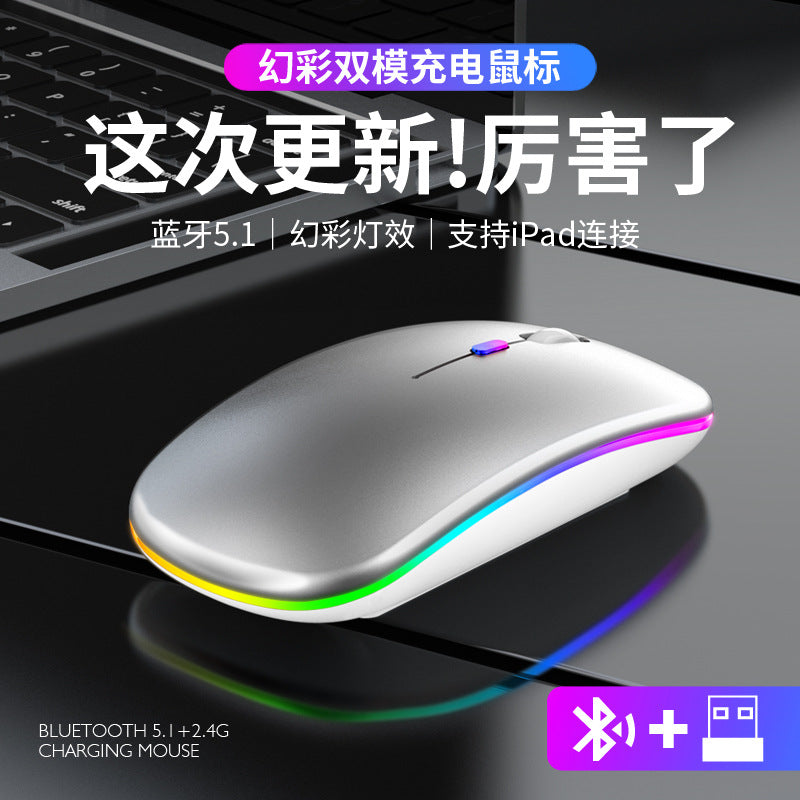 Quietclick Rechargeable Bluetooth Silent Mouse in silver with rainbow side lighting, on a dark laptop keyboard