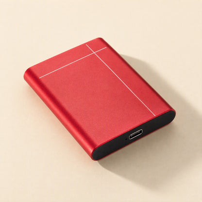 Metadrive – Red drive angled on a beige surface, showing white lines on its lid and the USB-C port on the black end