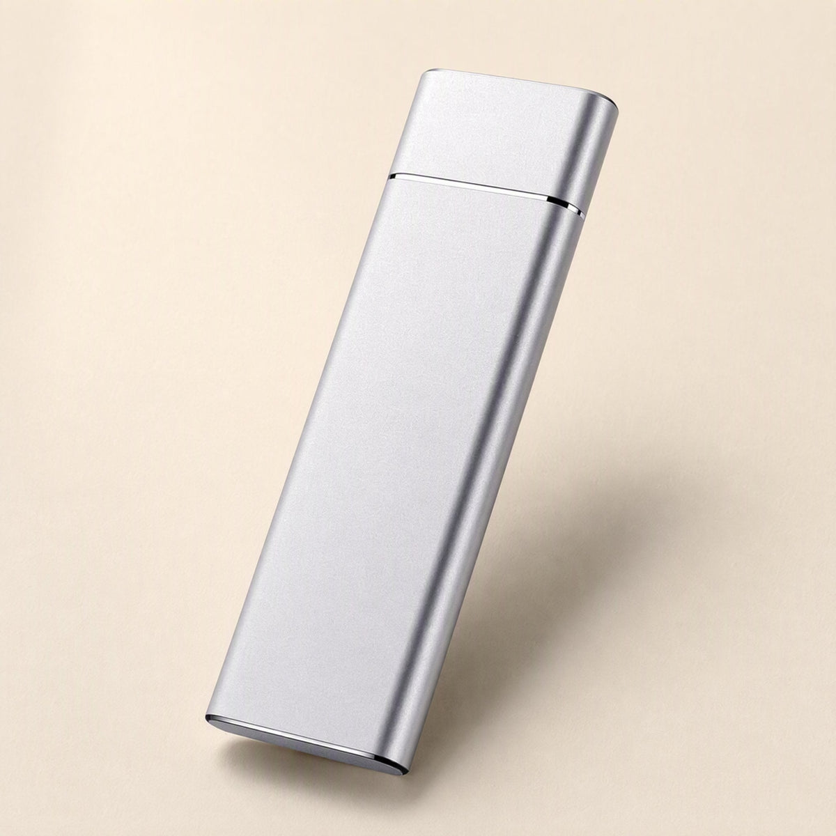 Pocketdrive External Solid State Drive – silver slim rectangular drive angled upright on a peach backdrop with a soft shadow